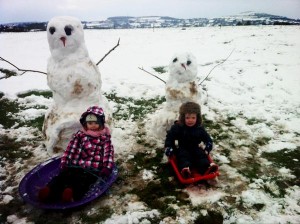 Children build a snowman on Saturday in Derriaghy