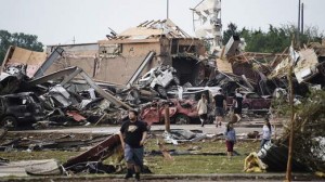 People walk near destroyed buildings and vehicles after a tornado struck Moore, Oklahoma, near Oklahoma City, 