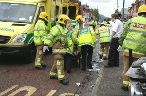 Paramedics and fire crews help to stretcher an injured person to an ambulance in east Belfast