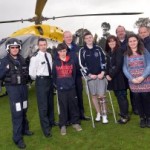Caolan McCluskey and family with emergency services who helped save his leg