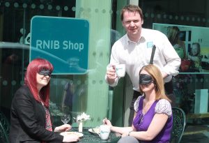 RNIB Northern Ireland’s Joe Kenny serves up the ‘Dining in the Dark’ challenge to Lucy Haugh and Ursula Comican from Fold Housing Association. 