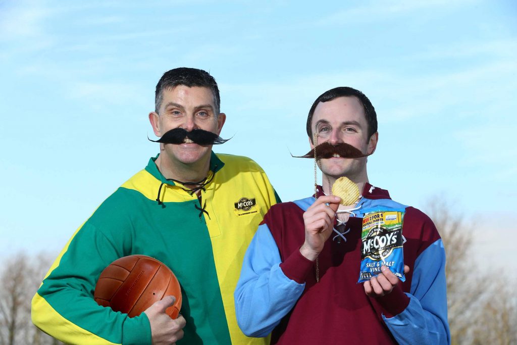 IN A DIFFERENT LEAGUE:  Rickie Watts (left) and John Baxter of KP Snacks (NI) donned some footie gear from yesteryear to launch McCoys Crisps tasty new deal with the oldest league in world football.  