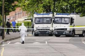 Army technical officers examine the remains of pipe bombs thrown at PSNI officers in north Belfast