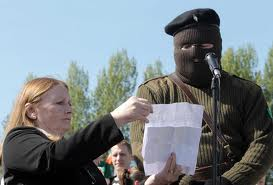 Marian Price helping to hold a statement for masked Real IRA man in April 2011