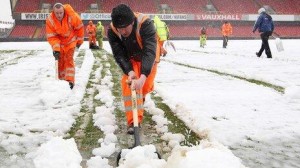 Ground staff clearing the snow at Windsor Park in south Belfast