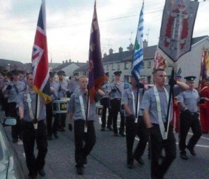 Jamie Bryson (second from left) carrying a UVFflag during a loyalist parade