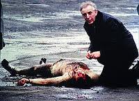 Fr Alec Reid administers the last rites to one of the murdered corporals