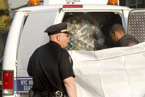 Police put the remains of Kevin Bell into the back of a truck with a bag of recycled bottles