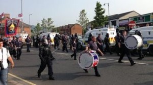 Orangemen pass Ardoyne shops in north Belfast amid a heavy police presence