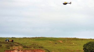 A PSNI helicopter circles over the scene of the farm tragedy accident in Castlewellan, Co Down