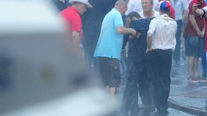 A dazed Nigel Dodds MP is held up after he was struck on the head by a missile