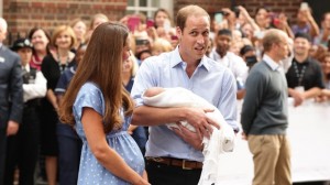 Prince William holds in his arms to the world's media his first born son