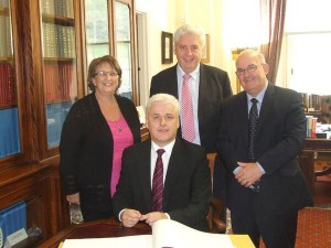 Fearghal McKinney signs up at the Assembly as Dolores Kelly, Alasdair McDonnell and Speaker Willie Hay look on