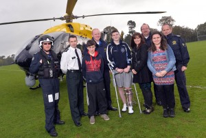Caolan McCluskey and family with emergency services who helped save his leg