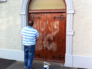 A member of the congregation paints out iRA graffiti on Presbyterian Church