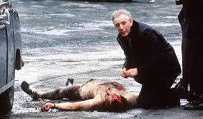 Fr Alec Reids gives the last rites to one of the two corporals murdered by the IRA in 1988
