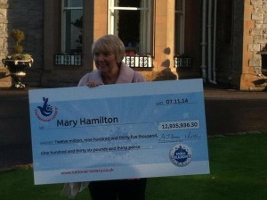 Bannons shopworker Mary Hamilton with her cheque for almost £13 million