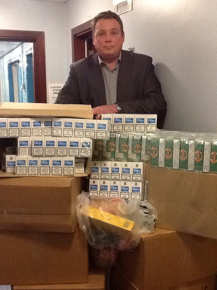 Detective Inspector Pete Mullan is pictured with some of the seized tobacco products.