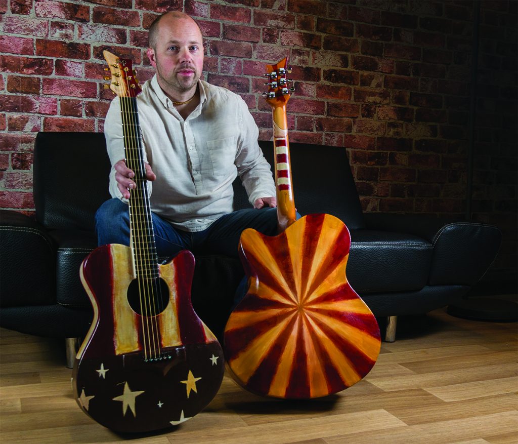 Emerald Guitars founder Alistair Hay with the two guitars painted by Brooklyn-based Belfast artist Oliver Jeffers who created the visual assets and art direction of legendary Irish band U2’s current Innocence and Experience World Tour.
