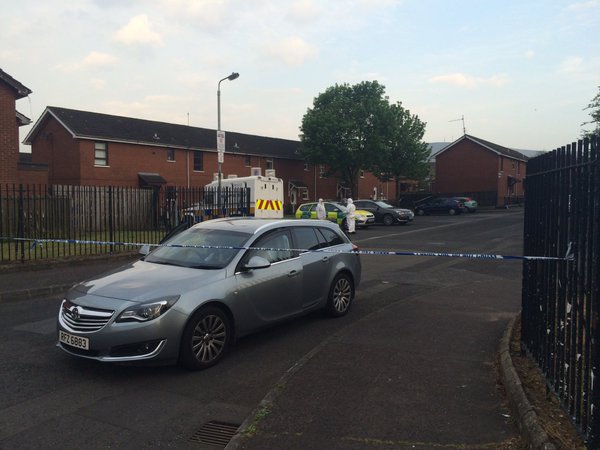 Police and forensic CSI teams examine the murder scene in Lady Street, west Belfast for clues to his killers