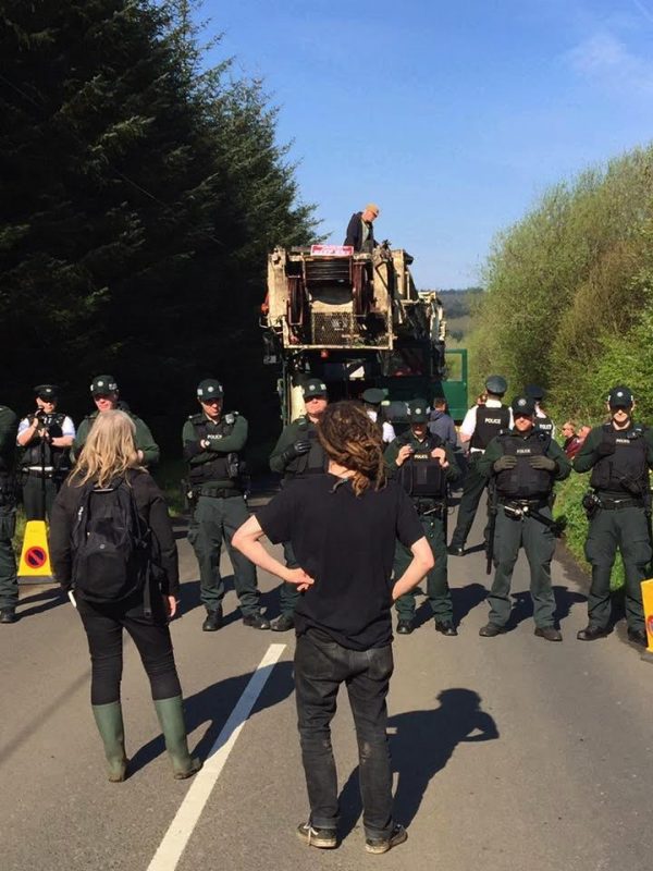 Tactical Support Group PSNI officers face down Stop The Drill campaigners on Paisley Road in Carrick